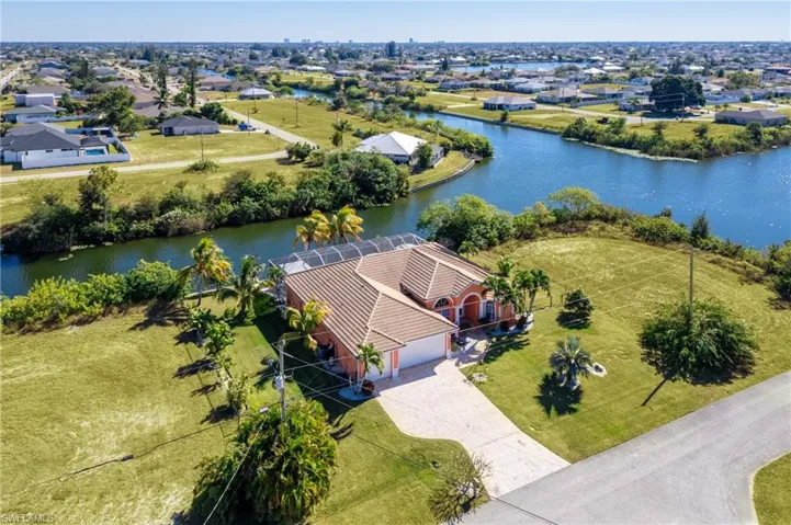 Aerial perspective of suburban area featuring a nearby body of water