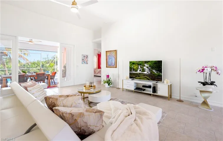 Living area featuring a ceiling fan and a high ceiling
