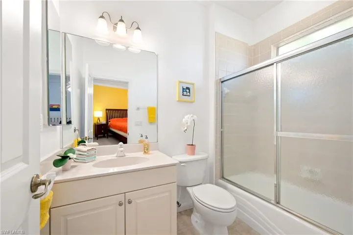 Full bathroom featuring vanity, enclosed tub / shower combo, ensuite bathroom, and light tile patterned flooring