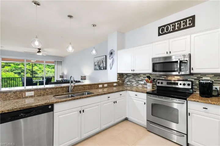 Kitchen with white cabinetry, a sink, stainless steel appliances, and backsplash