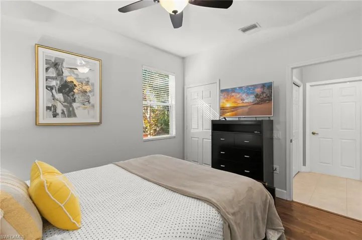 Bedroom with wood finished floors, visible vents, and a ceiling fan