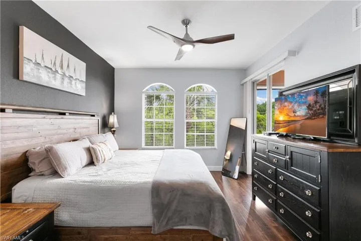 Bedroom featuring baseboards, dark wood-style flooring, visible vents, and a ceiling fan