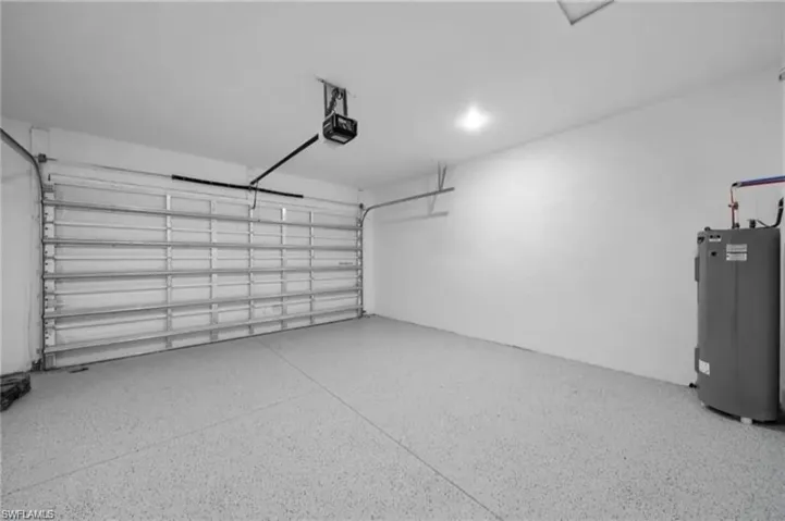 Garage featuring water heater and a garage door opener