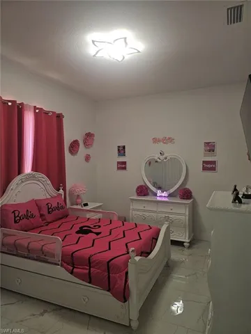 Bedroom featuring light marble finish floors