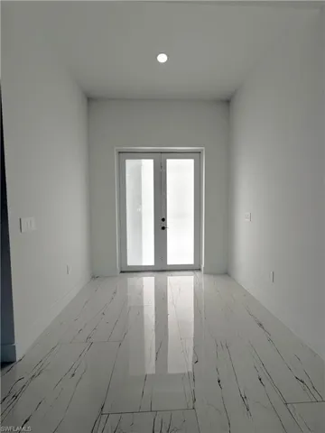 Unfurnished room with french doors, recessed lighting, and light marble finish flooring