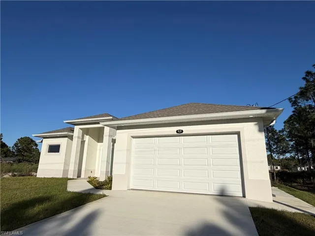 View of front of home featuring stucco siding, driveway, a shingled roof, and an attached garage