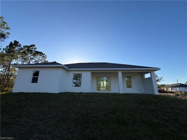 Back of house featuring stucco siding, a yard, and a patio area
