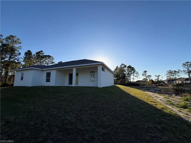 View of front facade featuring a front yard, stucco siding, and a patio area