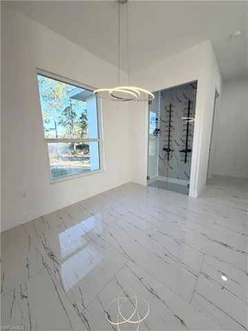 Unfurnished dining area with light marble finish floors