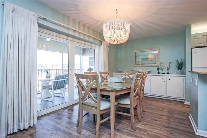 Dining space featuring an inviting chandelier, baseboards, and dark wood-type flooring