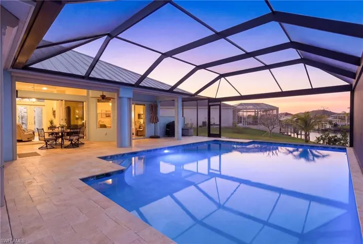 Dive into luxury in this oversized heated saltwater pool surrounded by elegant travertine decking.