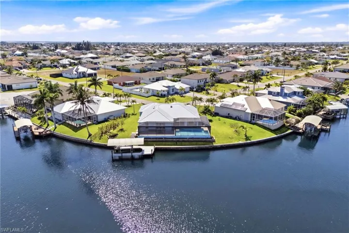 Stunning rear elevation showcasing the pool, lanai, and expansive canal views.