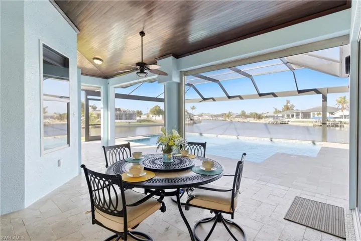 An impressive, covered lanai with custom wood ceiling, designed for relaxing and entertaining year-round.