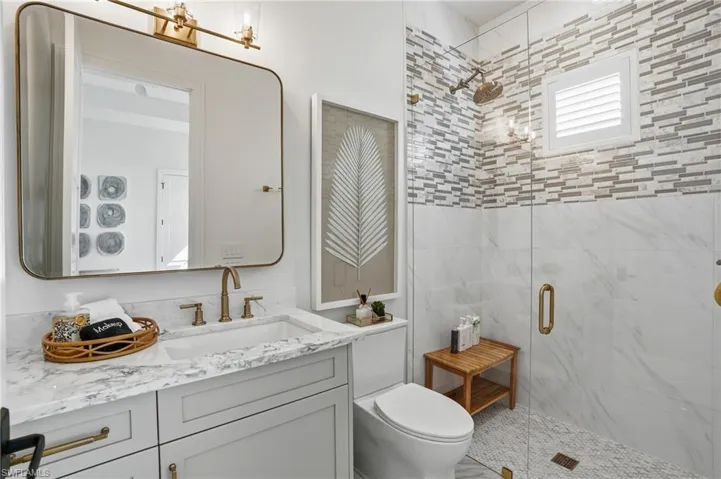 Full bathroom featuring vanity and a stall shower  - Virtually Edited Image