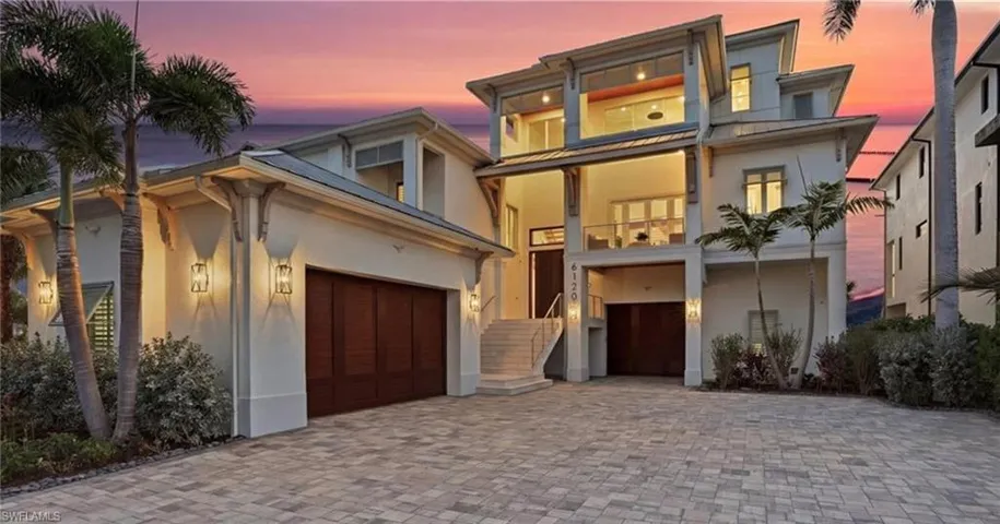 View of front facade with stucco siding, decorative driveway, a balcony, and a standing seam roof - Virtually Edited Image