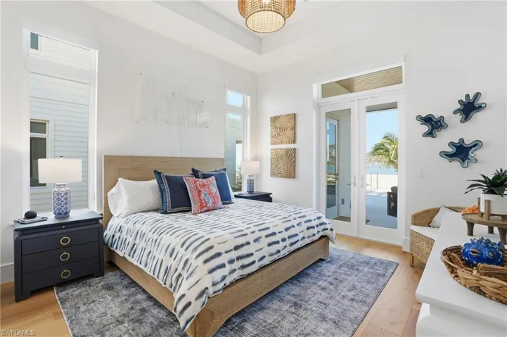 Bedroom with light wood-type flooring, french doors, and access to exterior - Virtually Edited Image