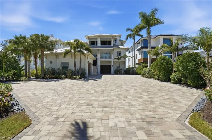 View of front of home with decorative driveway and a balcony - Virtually Edited Image