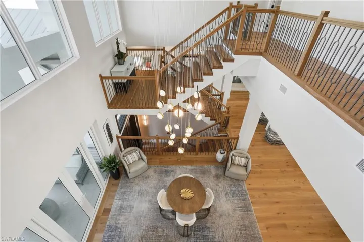 Stairway with wood finished floors and a high ceiling  - Virtually Edited Image