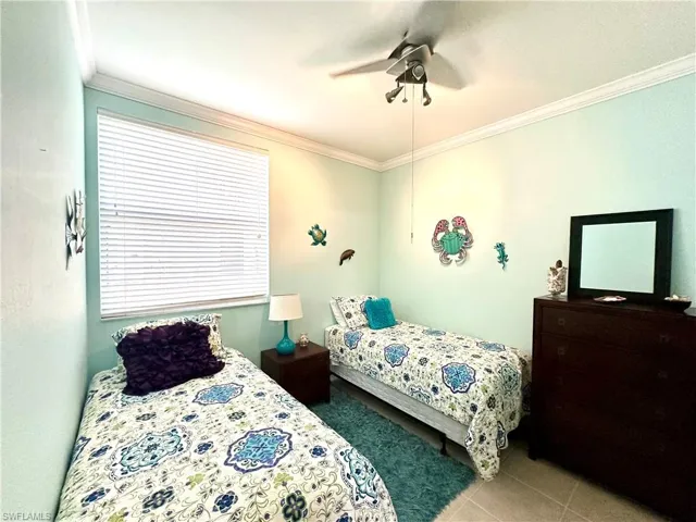 Tiled bedroom with crown molding and ceiling fan