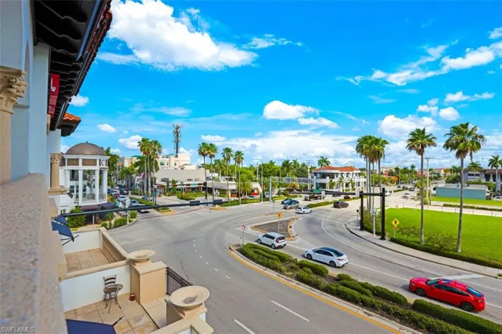 View of asphalt road featuring street lights, curbs, and sidewalks