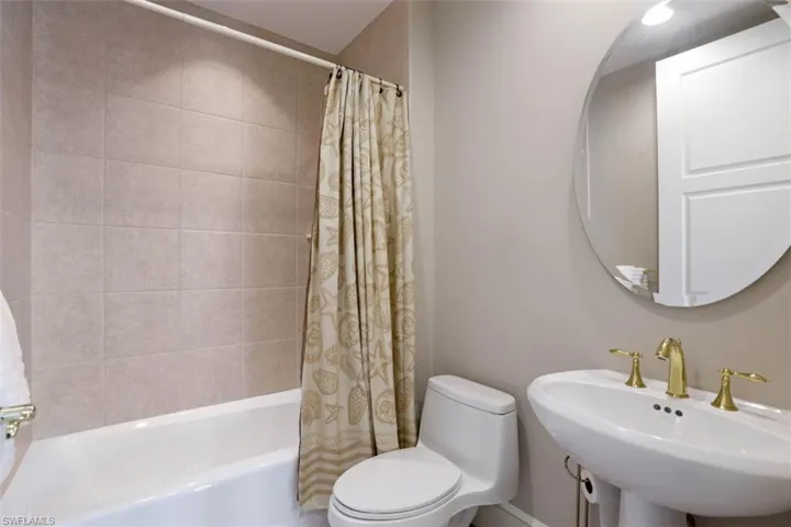 Full bath with a sink, toilet, and shower / bath combo