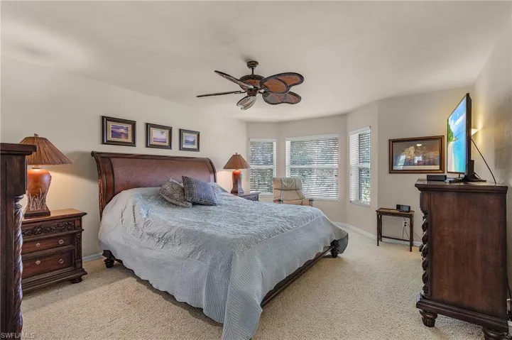 Carpeted bedroom with baseboards and a ceiling fan