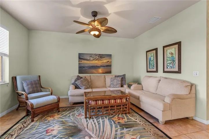 Living area with a ceiling fan and baseboards