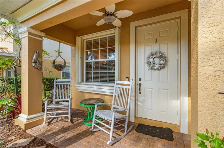 Entrance to property featuring a porch, stucco siding, and a ceiling fan