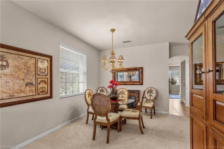 Sitting room featuring light carpet, healthy amount of natural light, a chandelier, and arched walkways