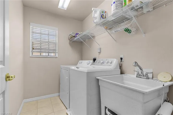 Laundry room featuring washing machine and clothes dryer and light tile patterned flooring