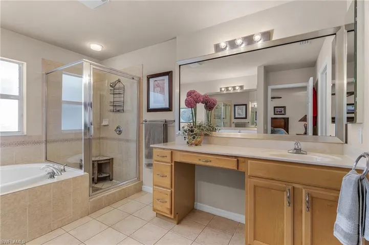 Full bathroom featuring tile patterned floors, a stall shower, a bath, and vanity
