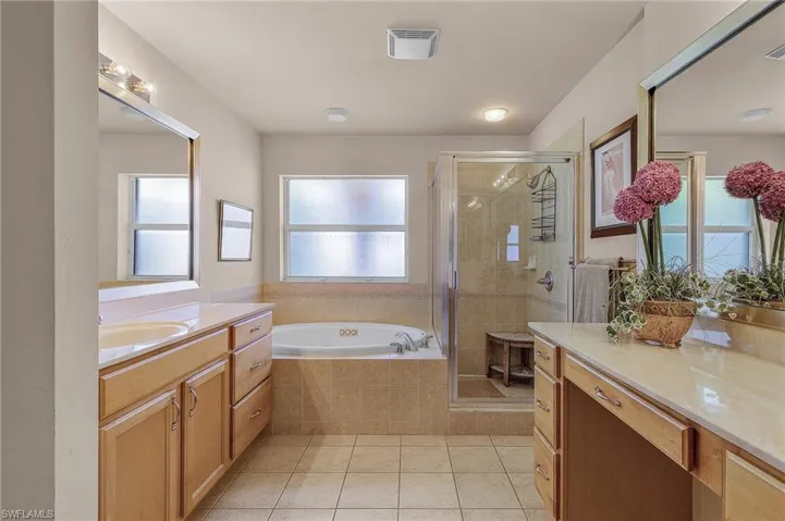 Full bathroom with vanity, a garden tub, a shower stall, and tile patterned flooring