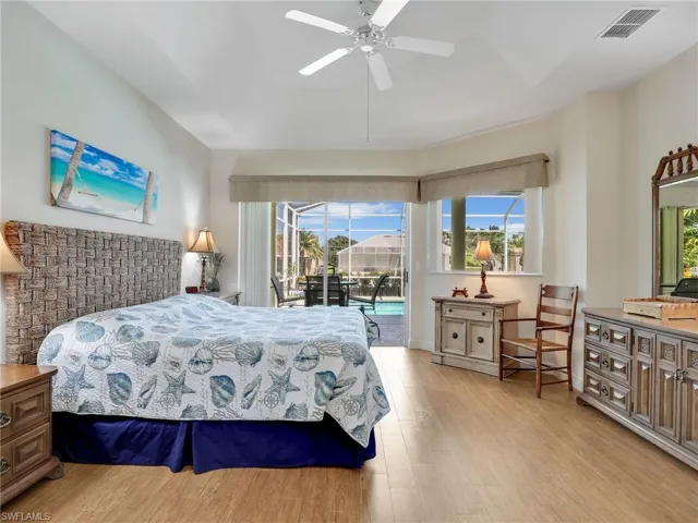 Bedroom with a sunroom, multiple windows, access to outside, and light wood-type flooring