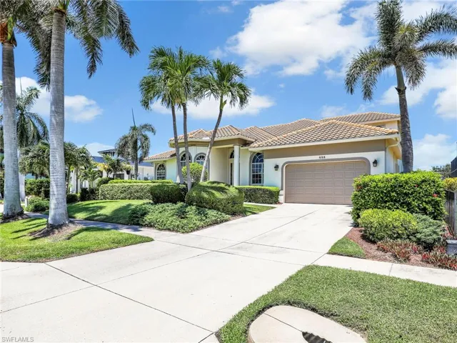 Mediterranean / spanish house with stucco siding, a garage, concrete driveway, a tile roof, and a front lawn