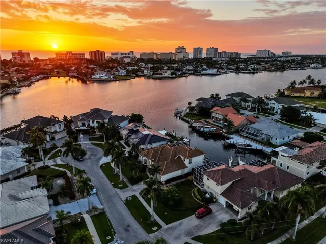 Aerial perspective of suburban area with city skyline and a large body of water