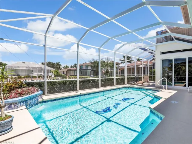 Outdoor pool with a sunroom, a patio area, and a lanai