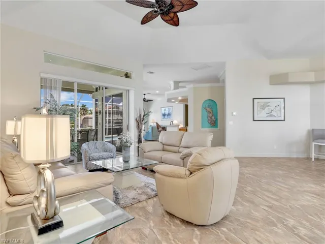 Living area with light marble finish flooring, a ceiling fan, and crown molding