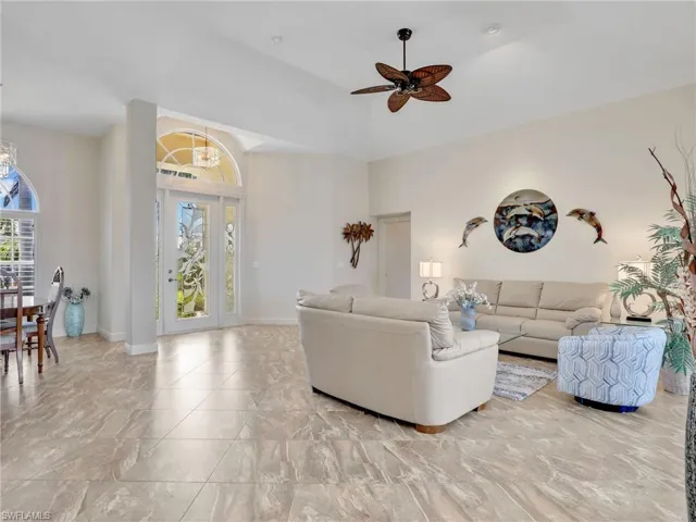 Living area with ceiling fan and baseboards