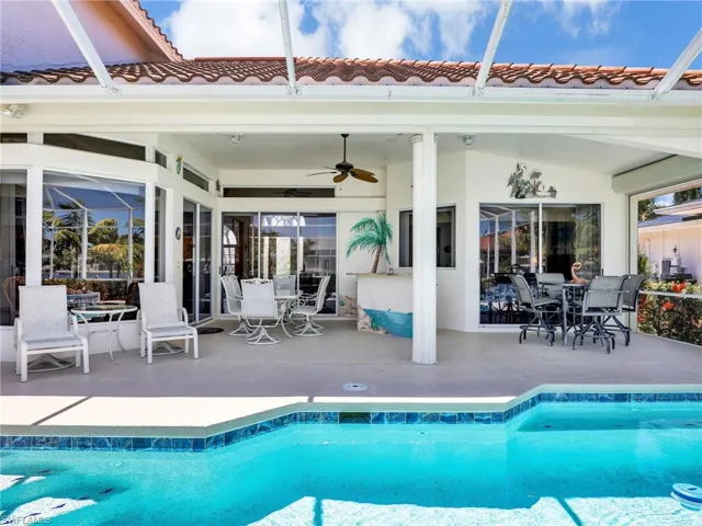 Outdoor pool featuring outdoor dining area, a patio area, ceiling fan, and a lanai
