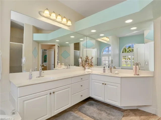 Bathroom with a stall shower, double vanity, and recessed lighting