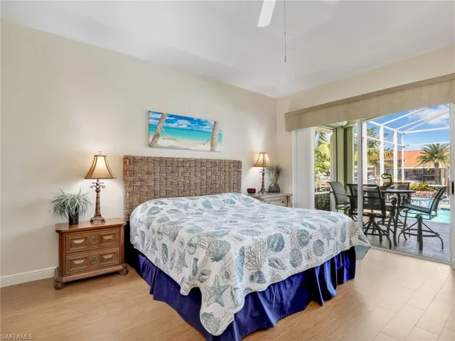 Bedroom with a sunroom, light wood-style flooring, a ceiling fan, and access to outside