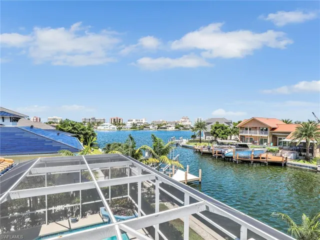 Dock area featuring a water view, glass enclosure, and a residential view