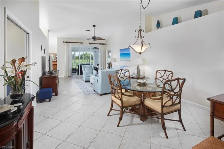 Tiled dining area with ceiling fan and lofted ceiling