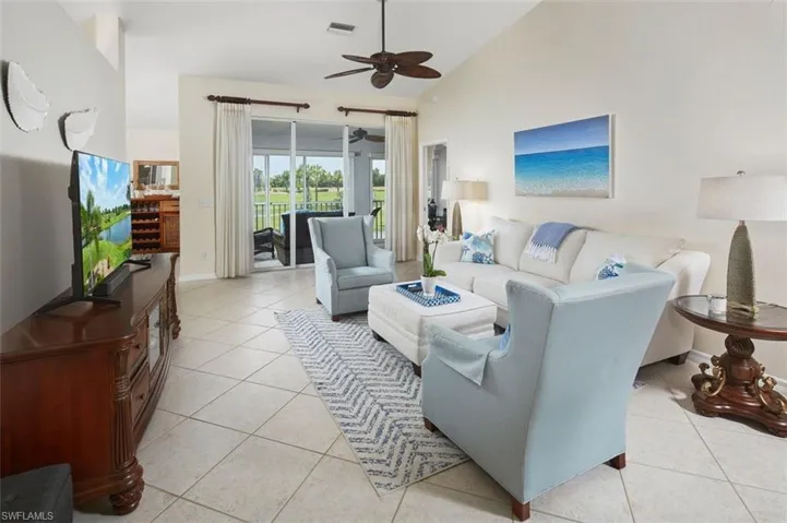 Tiled living room featuring high vaulted ceiling and ceiling fan