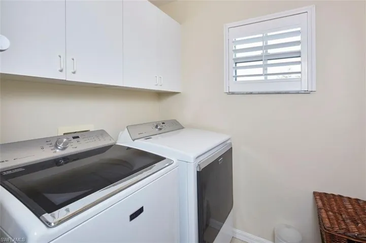 Clothes washing area with cabinets and washer and clothes dryer