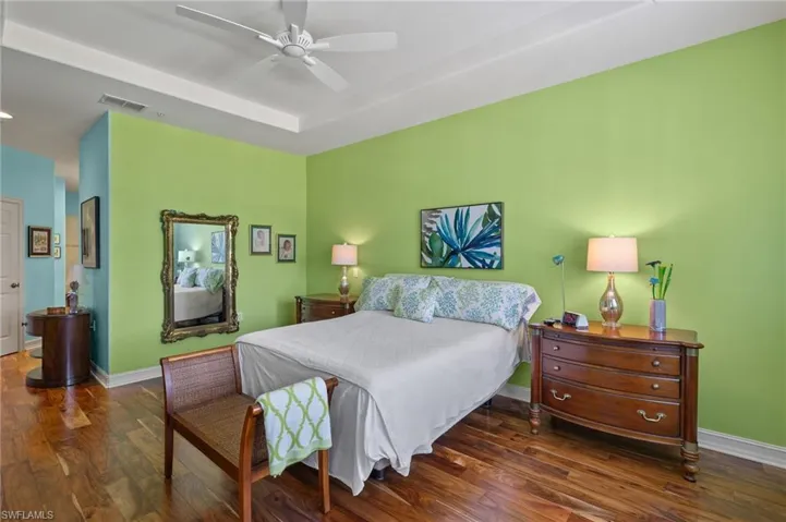 Bedroom with ceiling fan and dark wood-type flooring