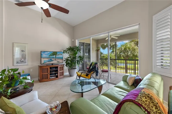 Tiled living room with high vaulted ceiling and ceiling fan