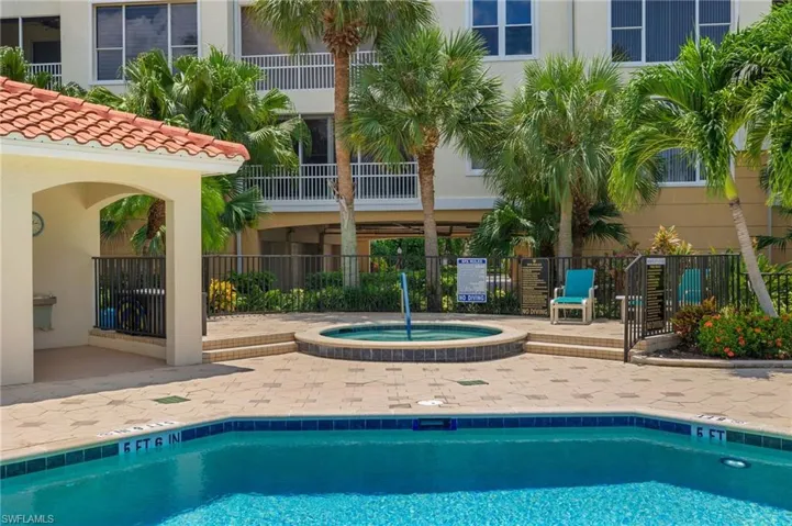 View of swimming pool with a hot tub