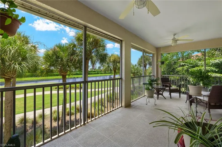 Unfurnished sunroom featuring ceiling fan and a water view