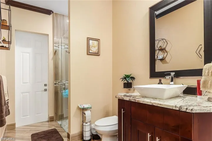 Bathroom with walk in shower, vanity, and toilet